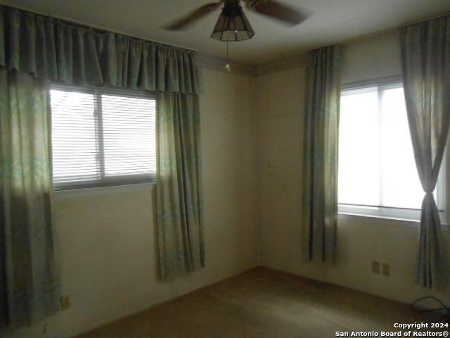 empty room featuring a healthy amount of sunlight and ceiling fan