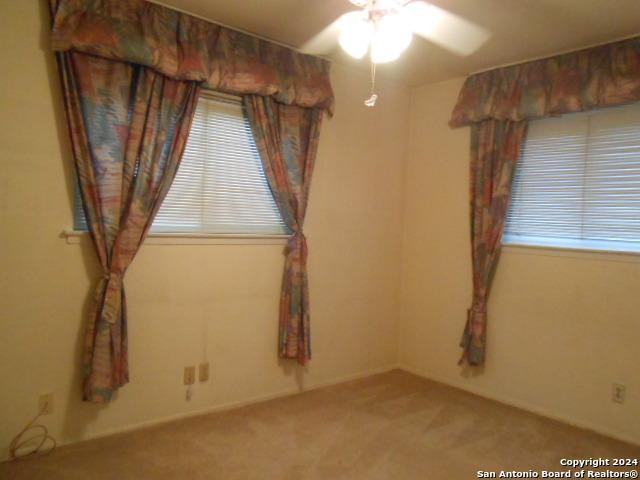 unfurnished room featuring ceiling fan and carpet flooring