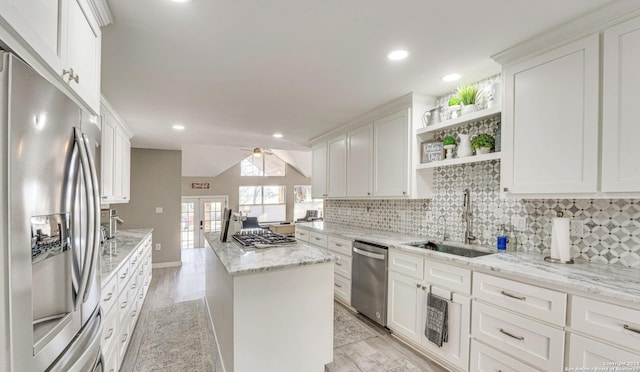 kitchen featuring appliances with stainless steel finishes, sink, white cabinets, light stone countertops, and light hardwood / wood-style flooring