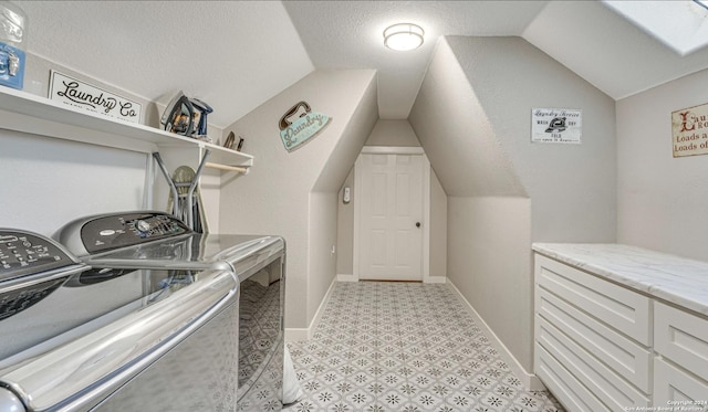 clothes washing area featuring washer and clothes dryer and a textured ceiling