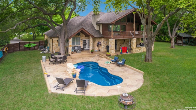 view of pool with a lawn, a deck, and a patio area