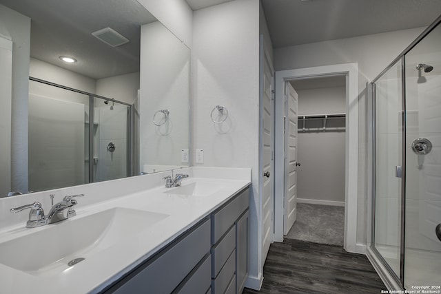 bathroom with hardwood / wood-style flooring, an enclosed shower, and vanity