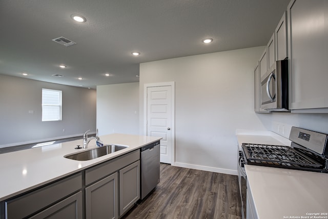 kitchen with a textured ceiling, appliances with stainless steel finishes, sink, dark hardwood / wood-style floors, and gray cabinets