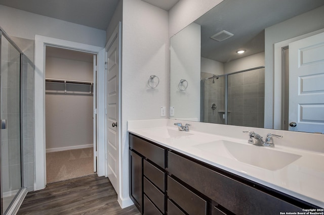full bath featuring a spacious closet, a sink, visible vents, and a stall shower