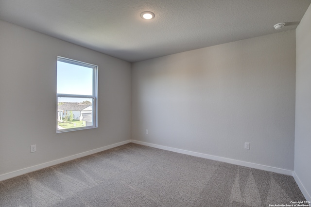 unfurnished room with a wealth of natural light and carpet