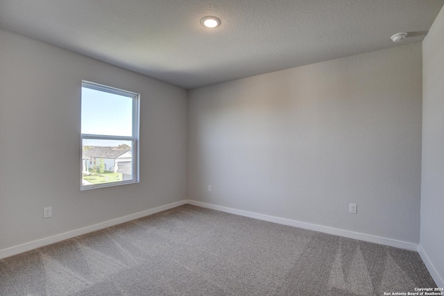 unfurnished room with baseboards and carpet flooring