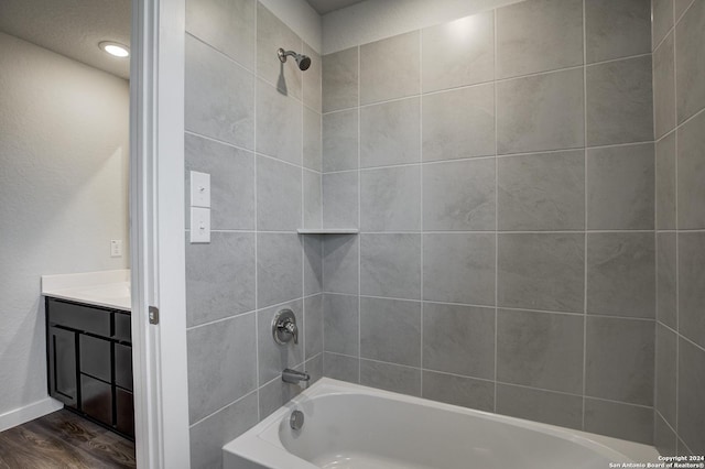 full bathroom with baseboards, wood finished floors, vanity, and tub / shower combination