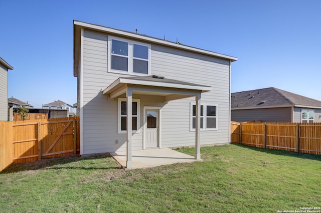 rear view of house featuring a yard, a patio, and a fenced backyard