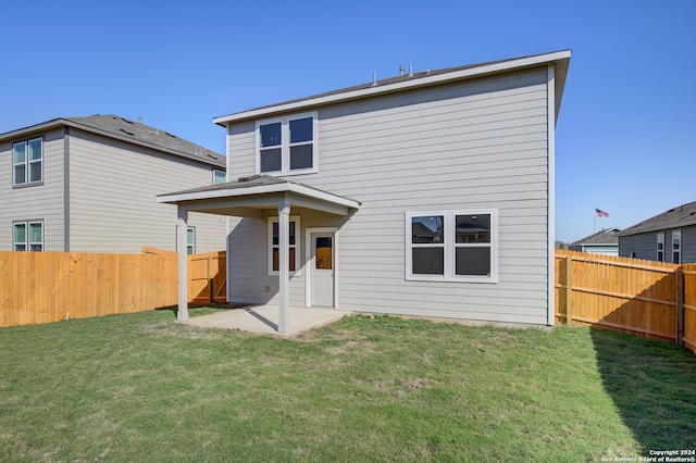 back of house featuring a lawn and a patio