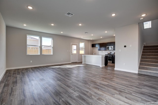 unfurnished living room featuring sink and dark wood-type flooring