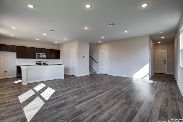 unfurnished living room with stairway, baseboards, and visible vents