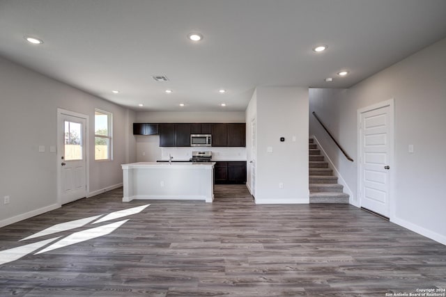 unfurnished living room featuring stairway, baseboards, dark wood-type flooring, and recessed lighting