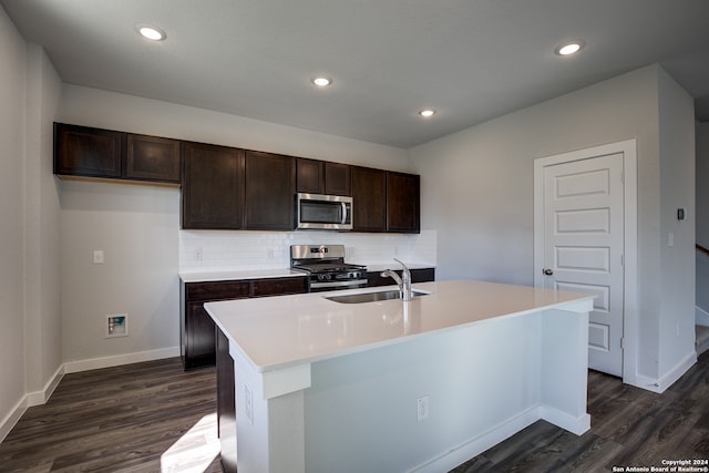 kitchen with sink, stainless steel appliances, a kitchen island with sink, and tasteful backsplash