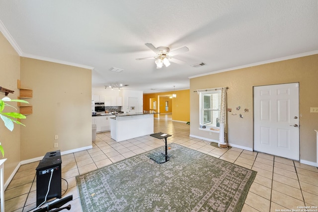 interior space featuring ceiling fan, a textured ceiling, and ornamental molding