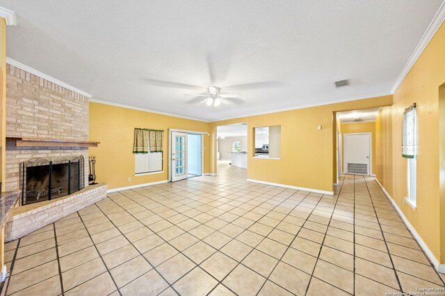 unfurnished living room with crown molding, ceiling fan, light tile patterned floors, and a brick fireplace