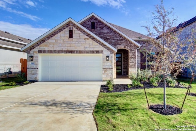 view of front of property featuring a garage and a front lawn