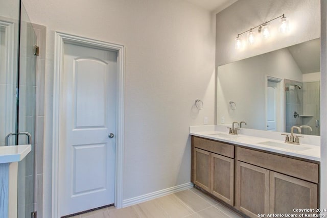 bathroom featuring a shower with door and vanity