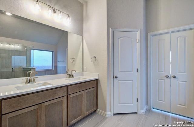 bathroom featuring a shower with shower door and vanity