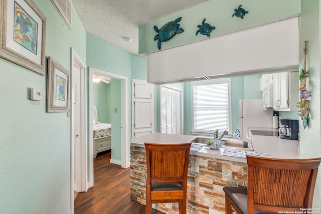 interior space featuring hardwood / wood-style flooring, sink, and a textured ceiling