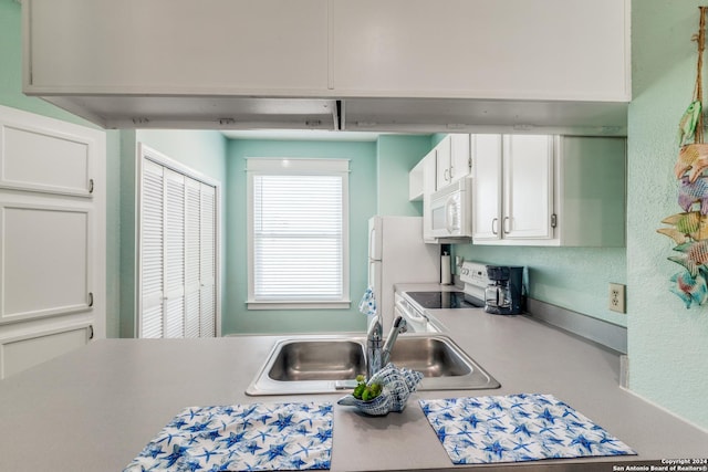 kitchen featuring white cabinetry, white appliances, and sink