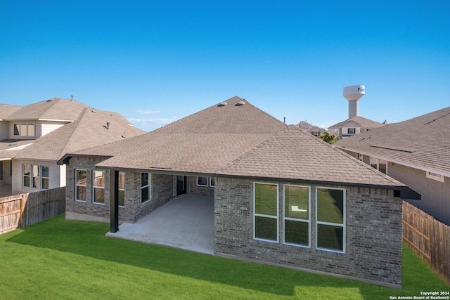 rear view of house with a patio and a yard