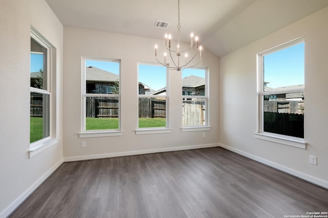 unfurnished dining area featuring dark wood-type flooring, plenty of natural light, a chandelier, and vaulted ceiling