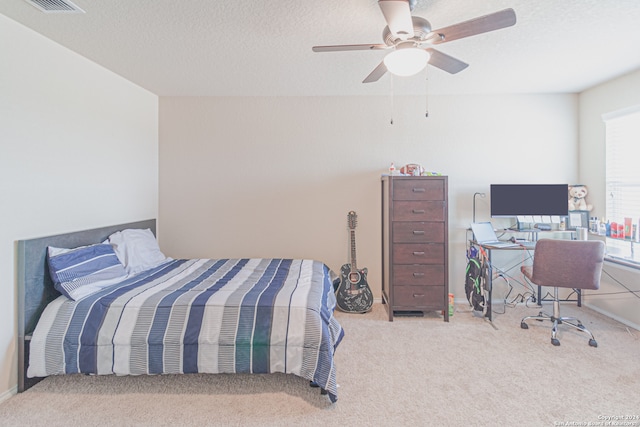 carpeted bedroom with a textured ceiling and ceiling fan