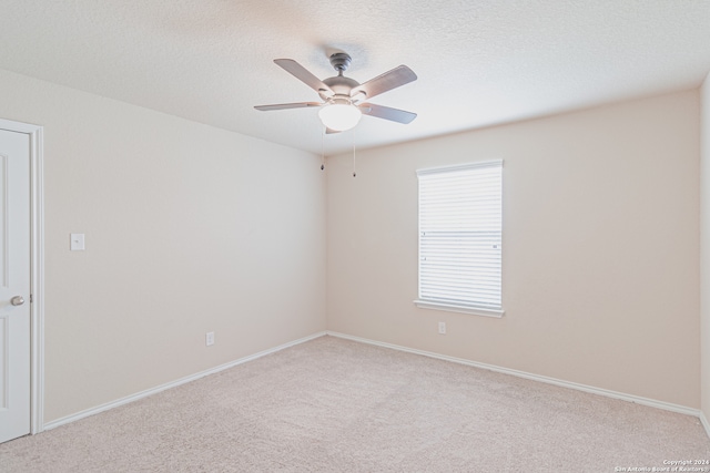 spare room featuring carpet floors, a textured ceiling, and ceiling fan