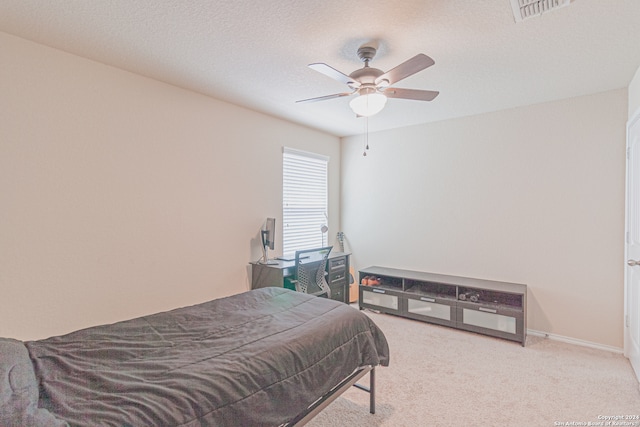 carpeted bedroom with a textured ceiling and ceiling fan