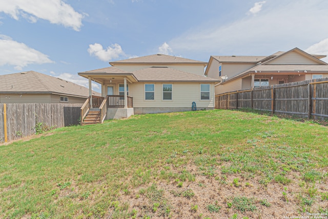 rear view of property with a yard