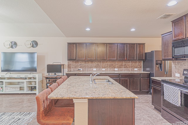 kitchen featuring electric stove, sink, light stone counters, light tile patterned floors, and backsplash