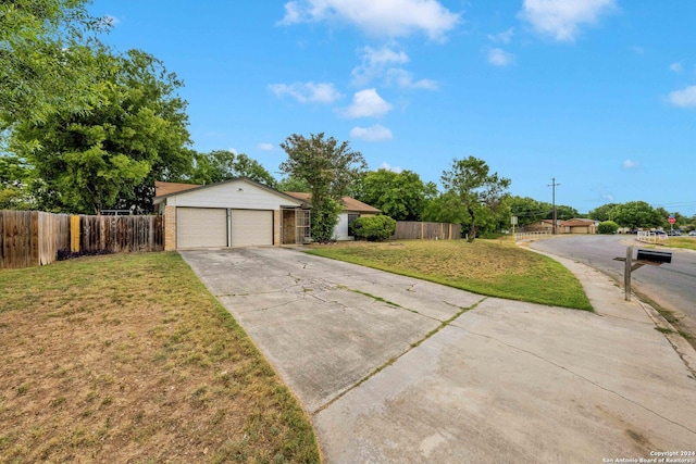 view of front of home with a garage, an outbuilding, and a front yard