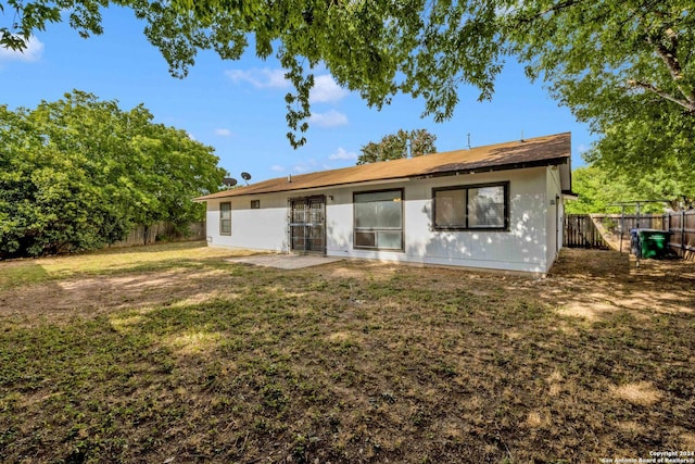 back of house with a yard and a patio