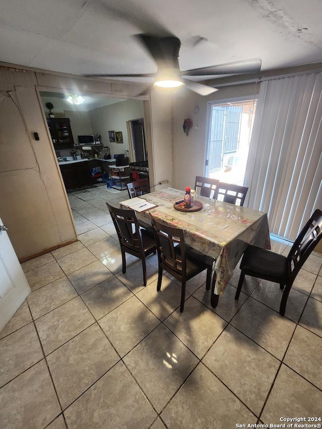 dining space featuring ceiling fan and light tile patterned floors