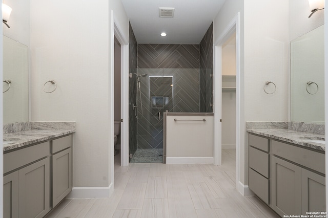 bathroom with vanity, a tile shower, and tile patterned floors