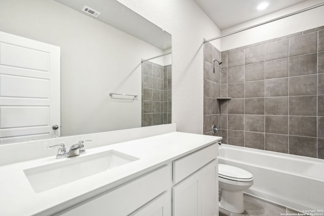 full bathroom with vanity, tiled shower / bath combo, and toilet