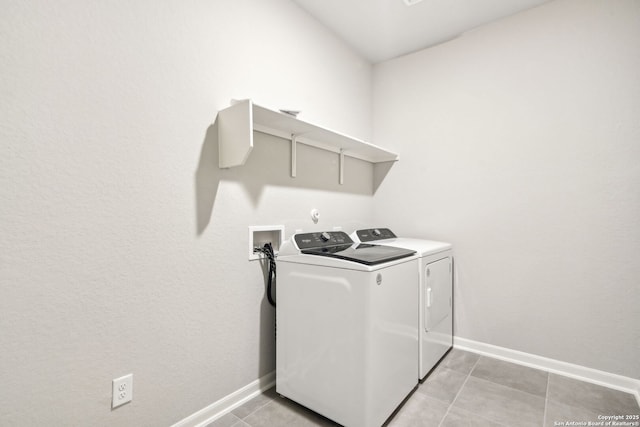 laundry area with separate washer and dryer and light tile patterned floors