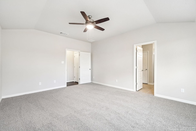 unfurnished bedroom featuring ceiling fan, light colored carpet, vaulted ceiling, and ensuite bath