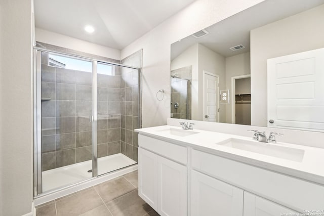 bathroom featuring tile patterned flooring, vanity, and walk in shower