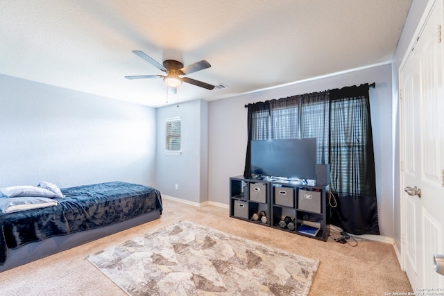 bedroom featuring ceiling fan and light carpet