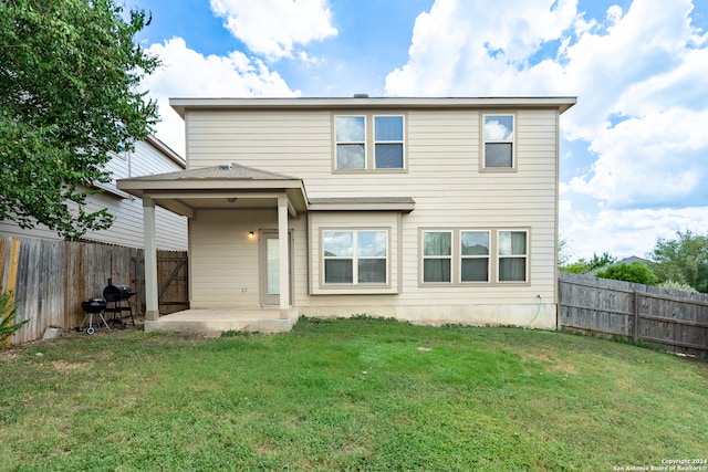 rear view of house with a patio area and a lawn