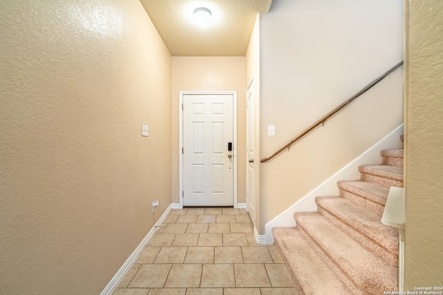 doorway to outside featuring a textured ceiling