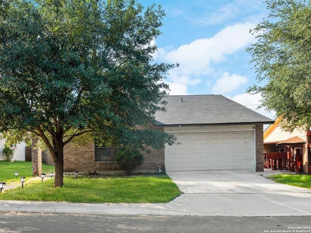 view of front facade with concrete driveway, brick siding, a front lawn, and an attached garage