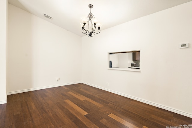 unfurnished room with hardwood / wood-style floors and a chandelier