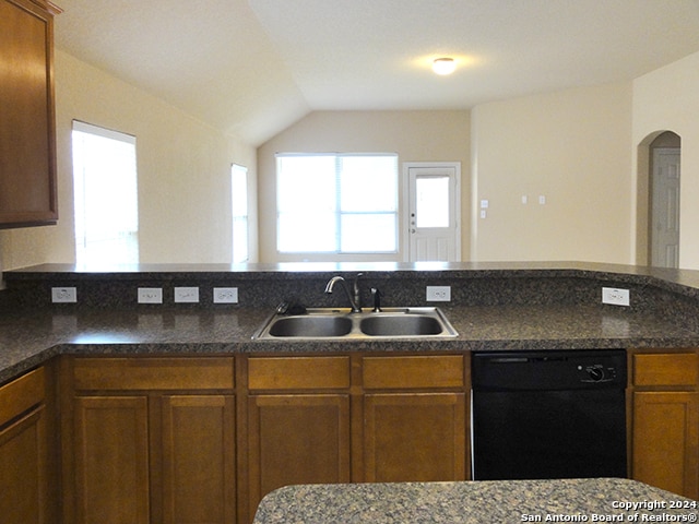 kitchen featuring plenty of natural light, black dishwasher, sink, and vaulted ceiling