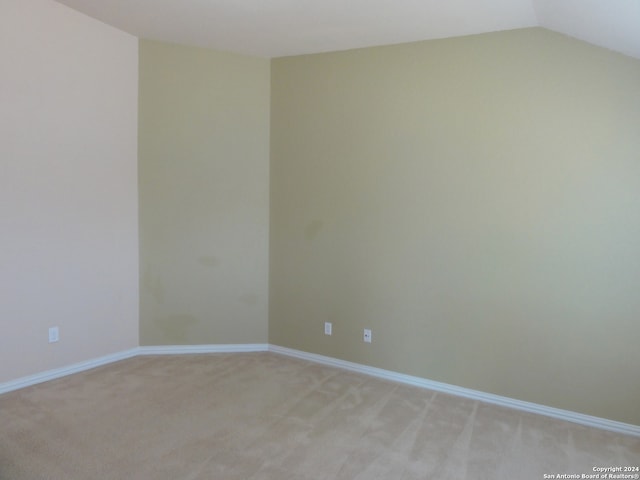 empty room with carpet floors and lofted ceiling