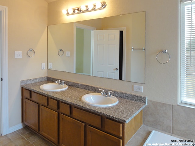 bathroom featuring tile patterned floors, a wealth of natural light, and double sink vanity