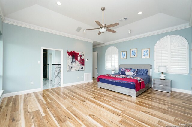 bedroom featuring ceiling fan, a water view, ornamental molding, a raised ceiling, and light hardwood / wood-style floors