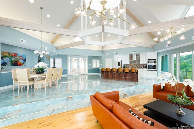 sunroom / solarium with a water view, vaulted ceiling with beams, and a chandelier