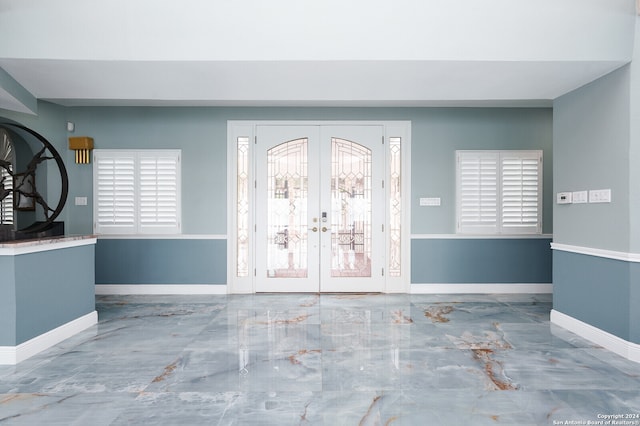 foyer entrance with tile patterned flooring and french doors